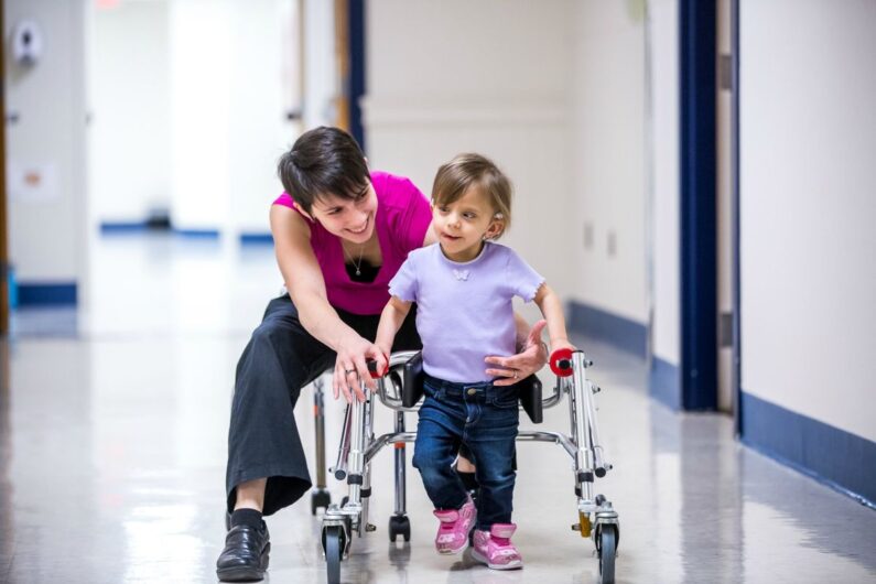 Pediatric orthopedic specialist applying a leg brace to a child