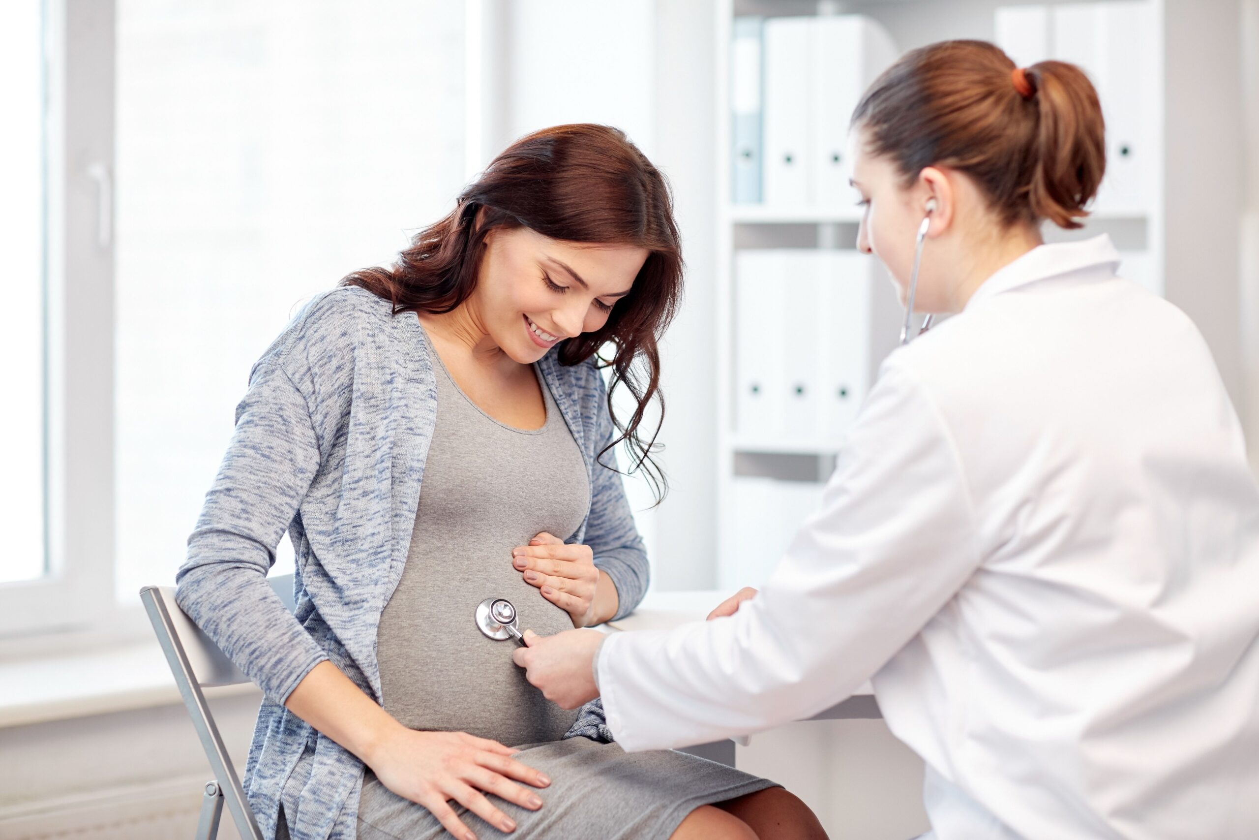 Pregnant woman during a prenatal visit with a gynecologist for routine pregnancy checkup