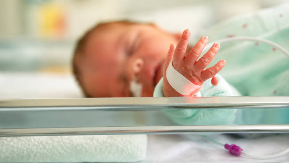 Paediatric orthopaedic specialist examining a newborn with a congenital limb deformity during an early developmental assessment.
